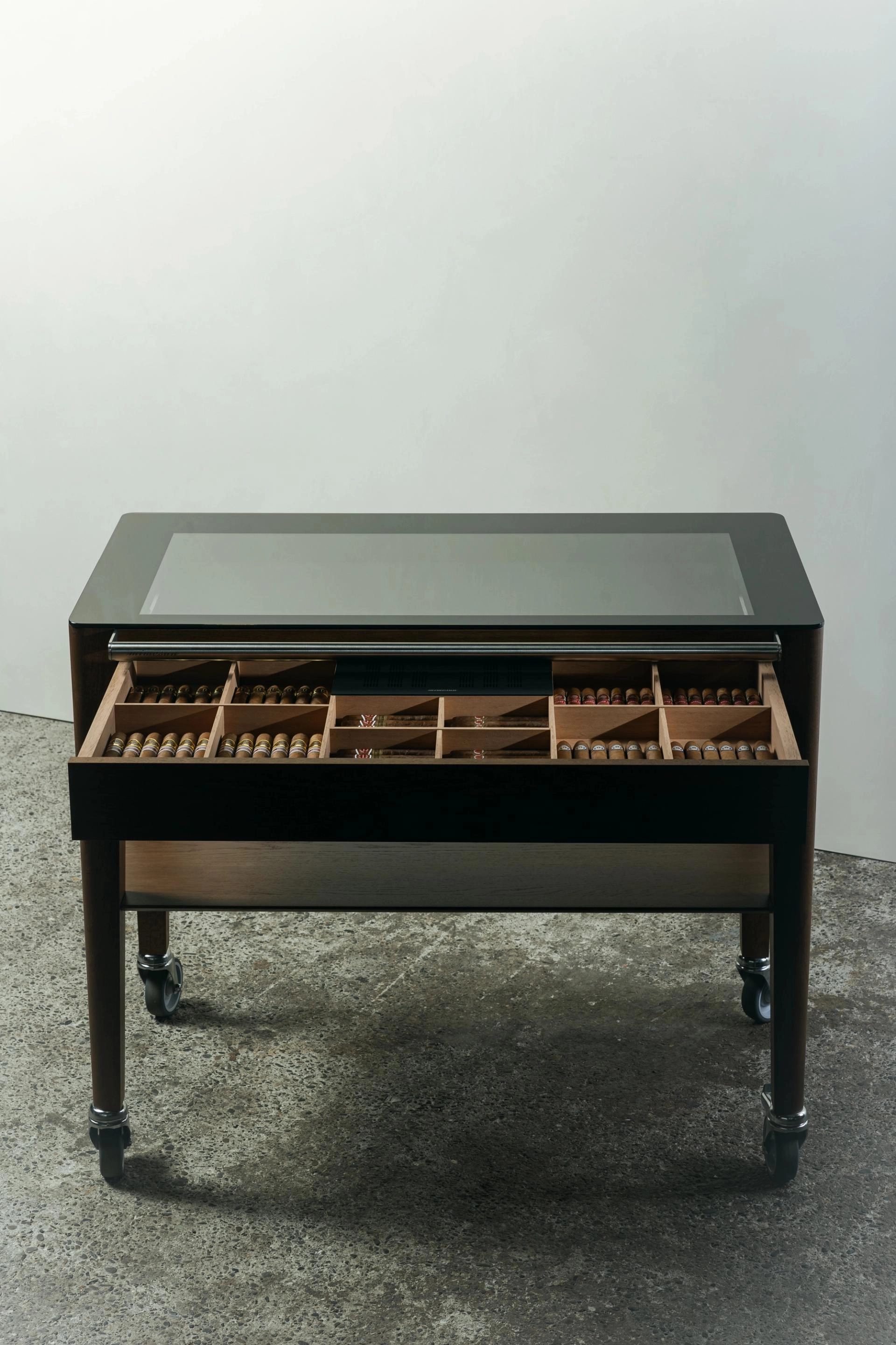Chariot à cigare en chêne de Bourgogne teinté avec un plateau en verre, un tiroir à cigares, une étagère inférieure et une poignée en acier inoxydable, monté sur quatre roulettes.